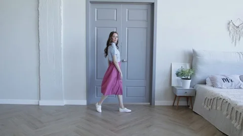 Young girl model posing and smiling next to bed and grey door. Slow motion Stock Footage 107829630