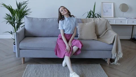 Young girl model posing and sitting on the couch. Slow motion Stock Footage 107829683