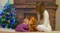 The young girl (mother) with baby at home by the fireplace 4k or 4k+ Resolution
