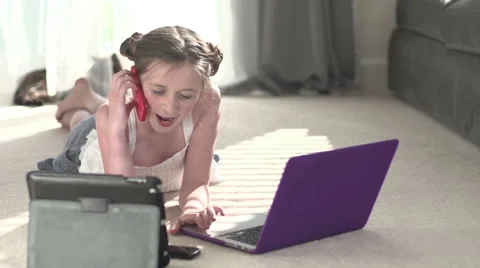 A young girl multi-tasks with technology. Stock Footage 44114295