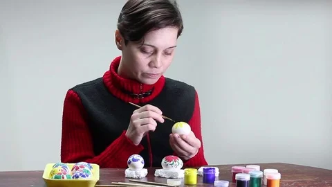 A young girl paints the Easter eggs Stock Footage 73148976