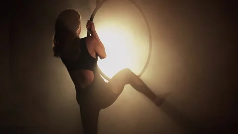 Young girl performs the acrobatic elements in the air ring Smoke background Stock Footage 233455804