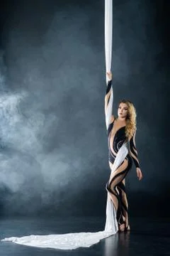 A young girl performs the acrobatic elements in the airrial silk. Studio Stock Photos