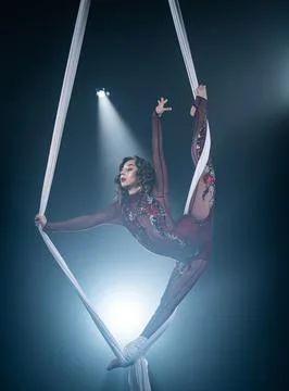 A young girl performs the acrobatic elements in the aerial silk. Studio shooting Stockfoto's