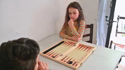 Young girl playing backgammon with focus and concentration Stock Footage 290049968