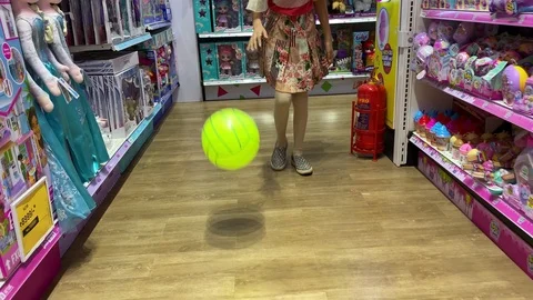 Young girl playing with a ball in a toy shop. Stock Footage