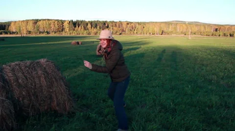 Young girl playing catch-up at the haystack Stock Footage 55459982