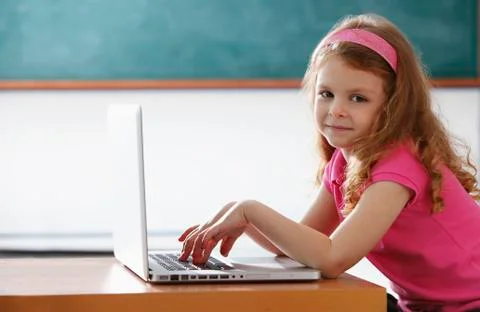 Young girl playing on a computer in class room Stock Photos