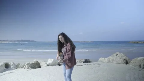Young Girl playing guitar while sitting on the beach.  Stock Footage 139495896