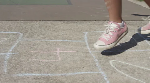 Young girl playing Hopscotch at park, closeup of feet Stock Footage