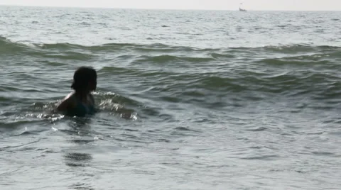 Young Girl Playing in Ocean Waves Stockbeeldmateriaal 59589263