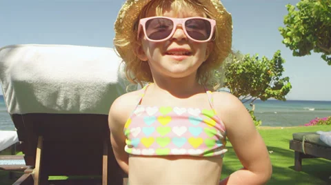 A young girl plays with a flower while at the beach Stock-Footage 33895103