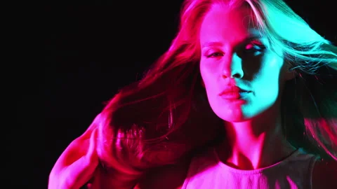 A young girl posing in a dark studio under neon light. Stock Footage 282106494
