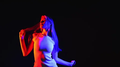 A young girl posing in a dark studio under neon light. Stock Footage 282106515