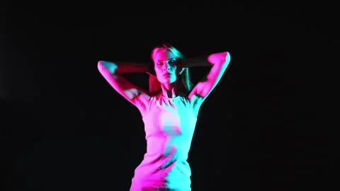 A young girl posing in a dark studio under neon light. Stock-Footage 282107027