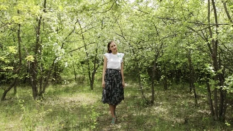 Young girl posing in front of a blooming garden, flowering Apple trees, summer , Video stock 108829209