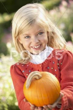 Young girl posing with pumpkin in garden Stock-Fotos