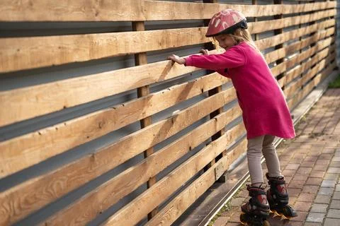Young Girl Practicing Roller Skating Outdoors Photos