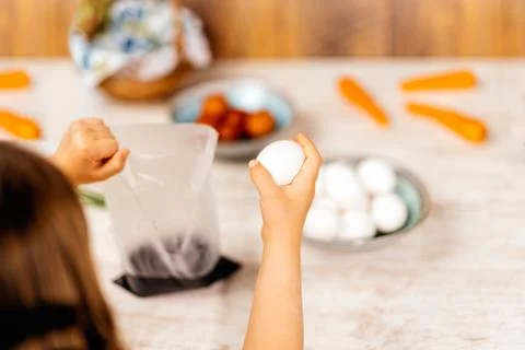 Young girl preparing Easter eggs for dying with food dye. Selective focus. Ea Stock-Fotos