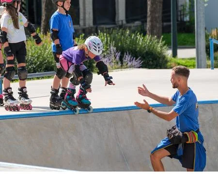 Young girl preparing for first inline skating bowl drop Stock Photos