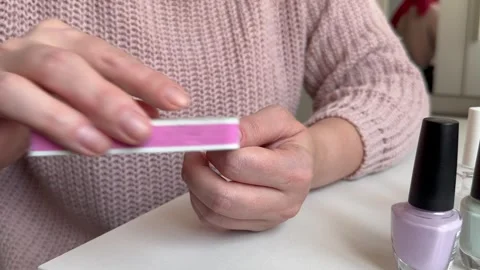A young girl processes her nails with a nail file, home manicure Stock Footage 255039737