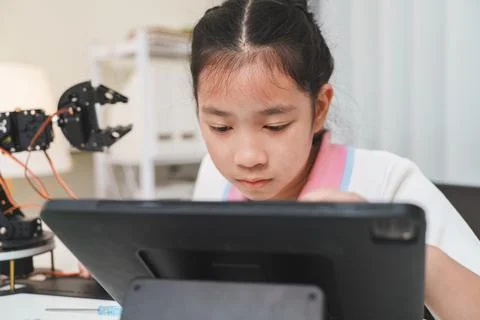 A young girl programming a robot using a digital tablet. Foto stock