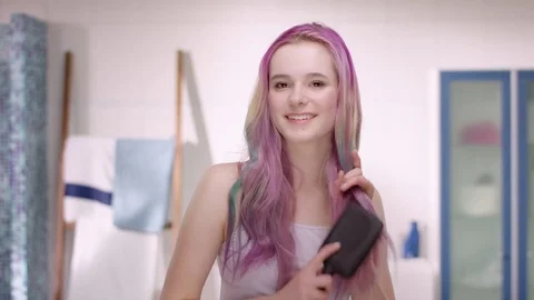 Young girl in puberty using a paddle brush before she is starting her day Stock Footage 73069617