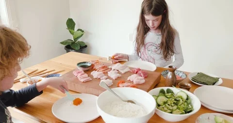 Young girl puts beginner training chopsticks on before eating fresh raw sashimi  Stock-Footage 115545445