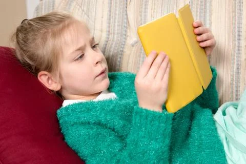 Young Girl Reading Tablet on the Sofa Stock Photos