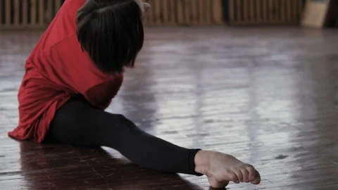 Young girl in a red dress does stretching in a dance studio in slow motion Vídeo Stock 123770836