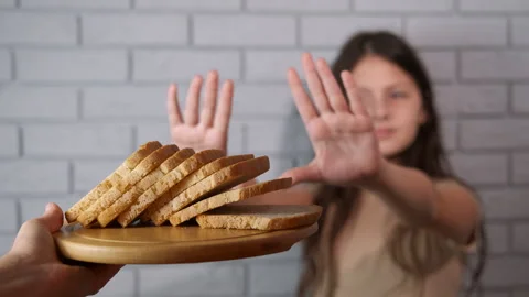 Young girl refusing bread expressing gluten intolerance Видео 334807586