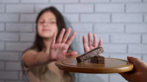 Young girl refusing to eat chocolate bars 스톡 동영상 330132124