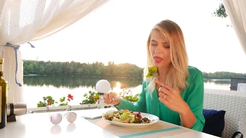 Young girl in restaurant eats taste salad and play with iPhone Stock Footage 78685285