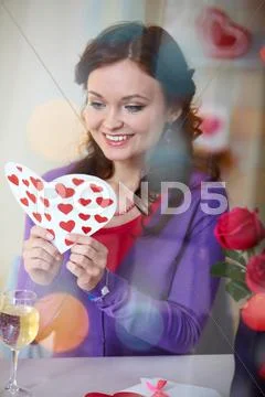 A young girl in restaurant holding valentine card Stock Photos