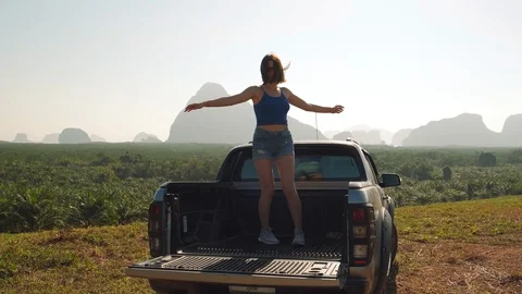Young girl revolves around herself in the back of a pick up truck Stock Footage 128293653