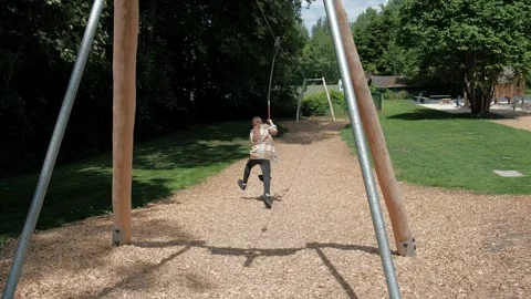 Young girl riding a fun zip line attraction at an outdoor playground during.. Stock Footage 337290089