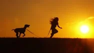 Young Girl Running With Her Dog Outdoors On Sunset, Backlight, Slow Motion. Stock Footage