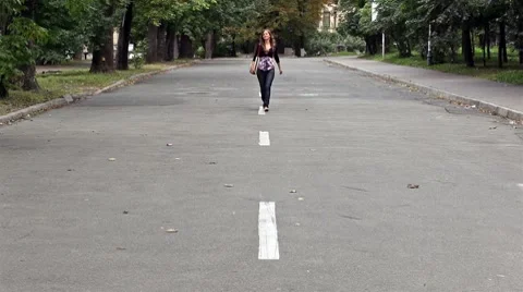 Young girl runs skipping on road Stock Footage