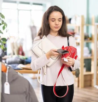 Young girl scanning QR-code on handbag in clothing store Stock-Fotos