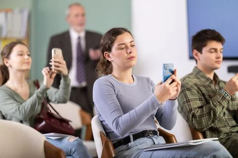Young girl scanning QR-code with mobile devices during presentation Foto stock