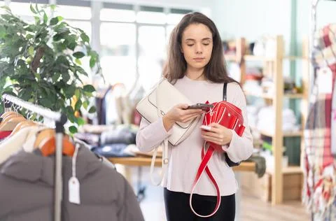 Young girl scanning QR-code on handbag in clothing store Stock-Fotos