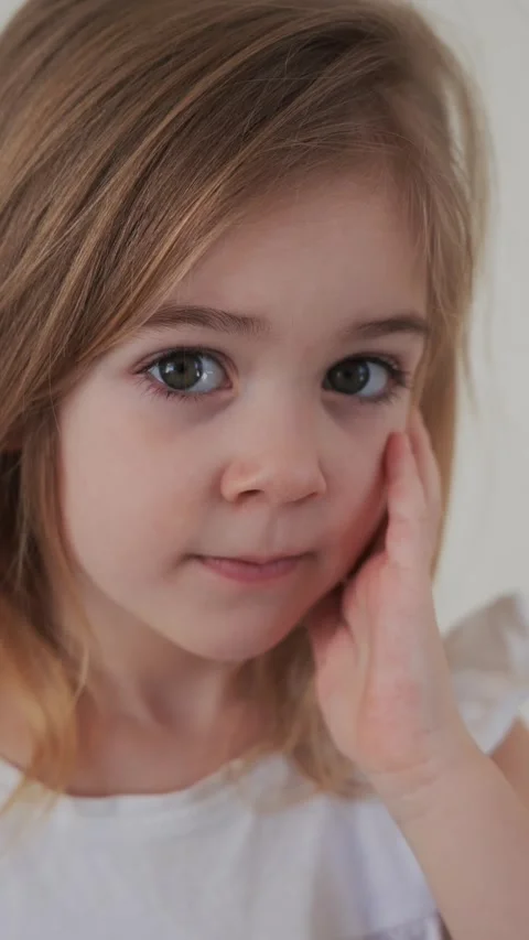 Young girl showing concern while thinking deeply in a quiet indoor setting Stock Footage 308659239