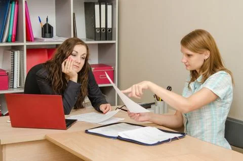 Young girl shows the errors in the documents office staff Stock Photos