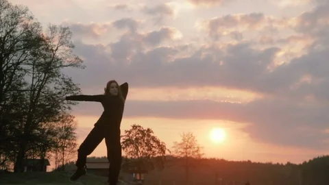 Young girl silhouette in black clothes dancing, at riverside Stock Footage