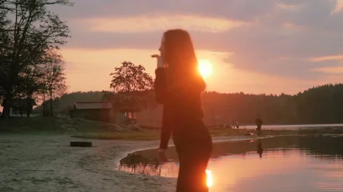 Young girl silhouette in black clothes dancing, at riverside Stock Footage
