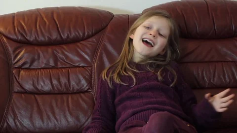 Young girl is singing and watching music channel on TV Stock Footage