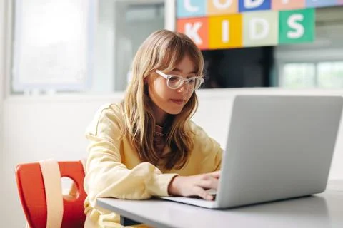 Young girl sitting in a coding class with a laptop, practicing her programm.. Foto stock
