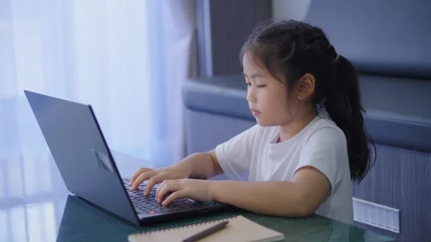 Young girl sitting at desk using laptop computer in a bright modern interio.. Stock Footage 337527319
