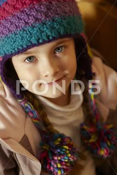 Young Girl Sitting On Wooden Seat Wearing Warm Outdoor Clothes Stock Photos