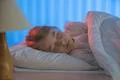 The young girl sleeping on the bed. Evening night time Photo